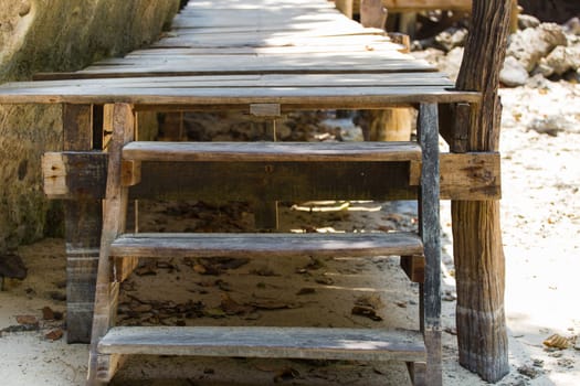 A close up shot of some old weathered beach stairs covered in sand