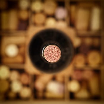 Close up shot of a bottle of red wine on a box with bottle cork, selective focus with view from above