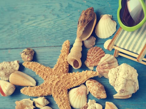 Vacation concept background with seashells and starfisch on a blue wooden background