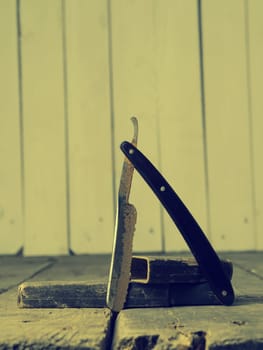 Old and rusty razor on a rustic workbench with space for text or image