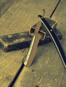 Old and rusty razor on a rustic workbench with space for text or image