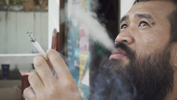 Portrait of adult man who is smoking cigarette