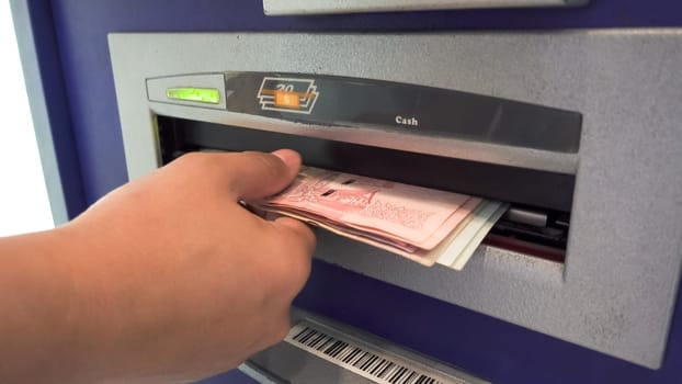 woman hand while she getting money from ATM