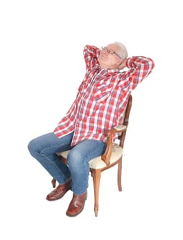 An senior citizen man in a checkered shirt and jeans sitting on a chair.with his hands behind his head, isolated for white background..