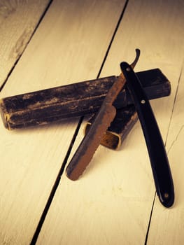 Old and rusty razor on a rustic workbench with space for text or image