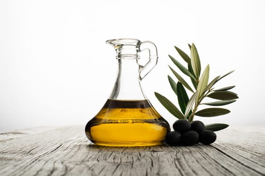 Olive oil and olive branch on the wooden table