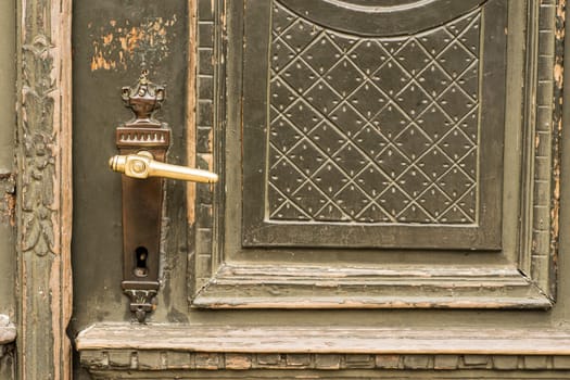 Brass door handles on elegant vintage green painted front door