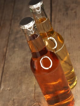 Two bottles of apple juice on an old rustic barn wood background