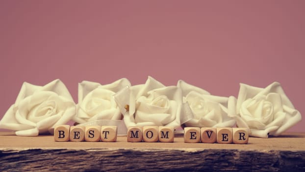 Mothers day concept image with wooden dices and the words Nest mom ever, using as background or header