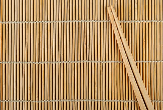 Abstract background bamboo sushi mat and chopsticks on top