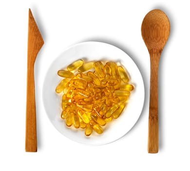 Fish oil on plate with wooden knife and spoon isolated on white background