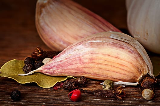 Clove of garlic bay leaf pepper cloves on wooden table