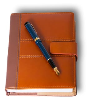 Fountain pen on top of the closed notebook isolated on white background