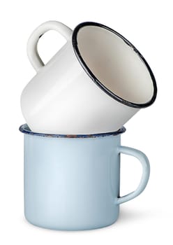 Two old enameled mugs on each other isolated on white background