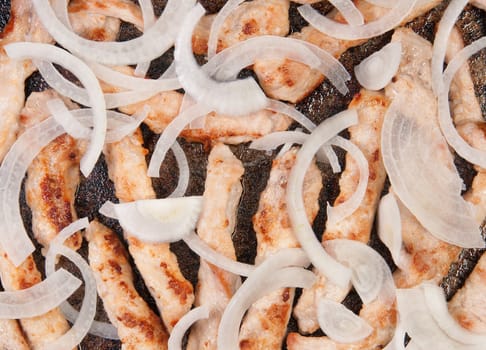 Meat Strips Fried With Onion In A Black Pan