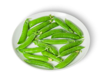Several pods of peas on a white plate isolated on white background