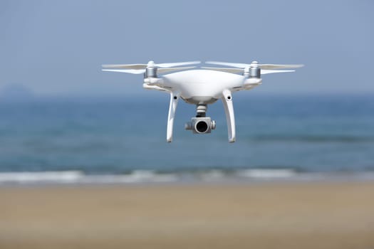 KAGAWA, JAPAN - April 03, 2017: Drone Dji Phantom4 Pro equipped with high resolution video camera hovering in air with beach and clear blue sky in the background