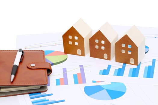 Miniature model of house on chart printed documents