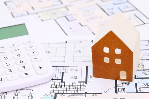 Miniature model of house and blueprints