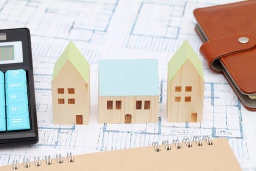Miniature model of house on blueprints