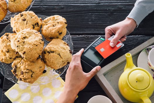 A contactless card payment is being made in a cafe.