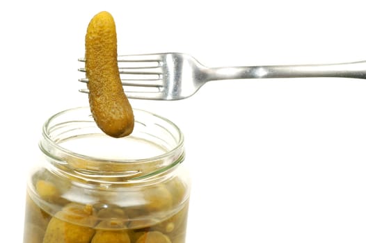 The bottle of pickles and a fork with the cucumber are on white background.