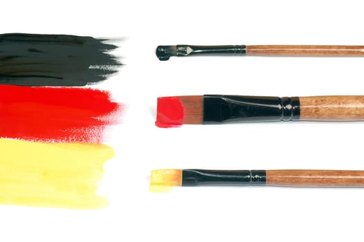 Unfinished German flag is painted with three paintbrushes.