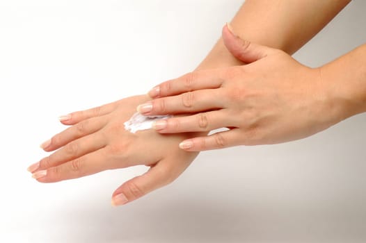 The hand is daubing another hand with hand cream.
