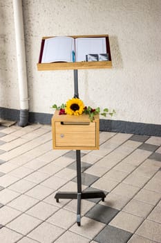 Book of condolences with shredder and self-made mourning cards on a movable transport stand