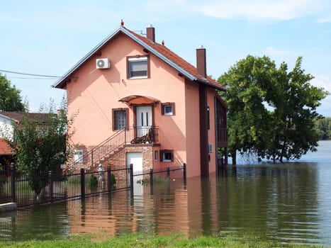 big flooded house with blue sky and white clouds in high water