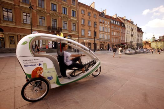 A Electro Taxi in the Old Town in the City of Warsaw in Poland,East Europe.