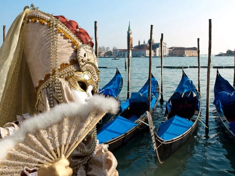 mask and gondola boats waiting for turists in the Venice