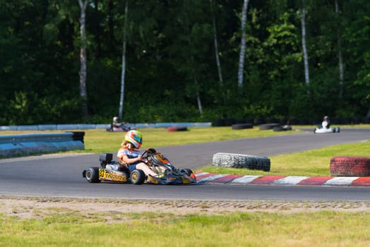 OLDENZAAL, NETHERLANDS - JUNE 7, 2016: Karter taking a sharp curve on an outdoor karting track