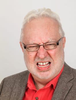 Angry senior clenched with teeth exposed on a white background