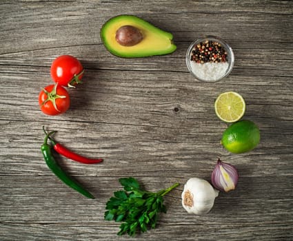 Fresh ingredients for Avocado guacamole on wooden table