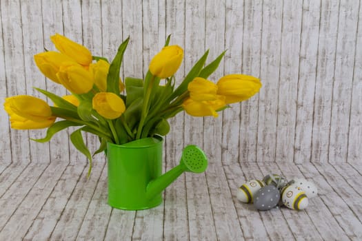 Yellow tulips with Easter eggs on background with structure