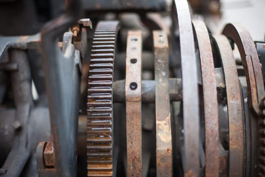 Old rusty printing machine complex mechanism of metal with close up details