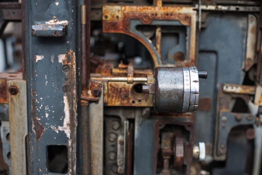Old rusty printing machine complex mechanism of metal with close up details