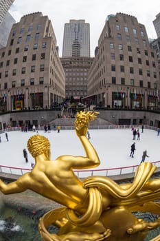 New York City, USA - March. 2015: Golden Prometheus statue and Rockefeller Center and tourists and ice skaters visiting Rockefeller Center ice skate rink on 24th of March,2015.
