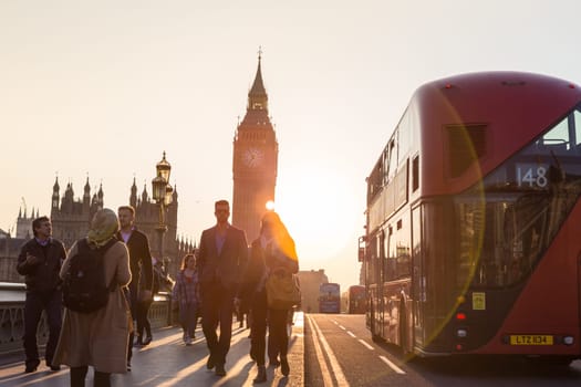 London, UK - April 7, 2015: Traffic and pedestrians passing on Westminster Bridge in sunset on 7th of April, 2017 in London. Big ben and Palace of Westminster aka Houses of Parliament in background.
