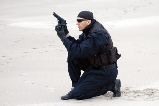 The security man with gun is in desert.