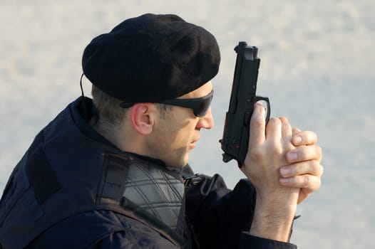 The security man is holding gun in his hands.