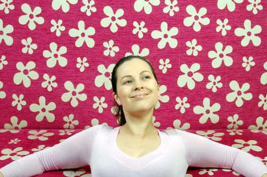 Woman is daydreaming in front of pink couch.