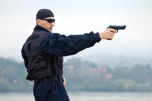The security man is shooting with gun.