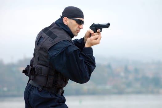 The security man is shooting with gun.