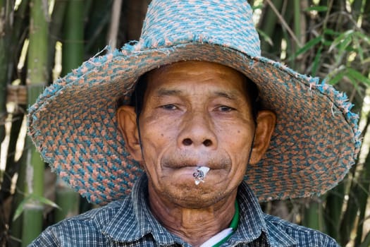 Old Asian man with cigarette Portrait of a smoking Thai man