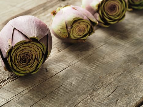 Healthy food concept with organic artichoke on a rustic wooden table, natural light with selective focus