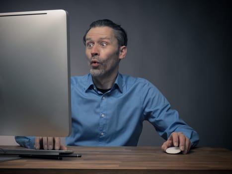 Handsome business man working on an office table with a computer