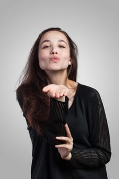 Young woman giving a kiss, isolated on white