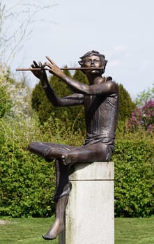 Sculpture of a flute player in the garden